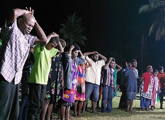People praying together at an outdoor ministry gathering